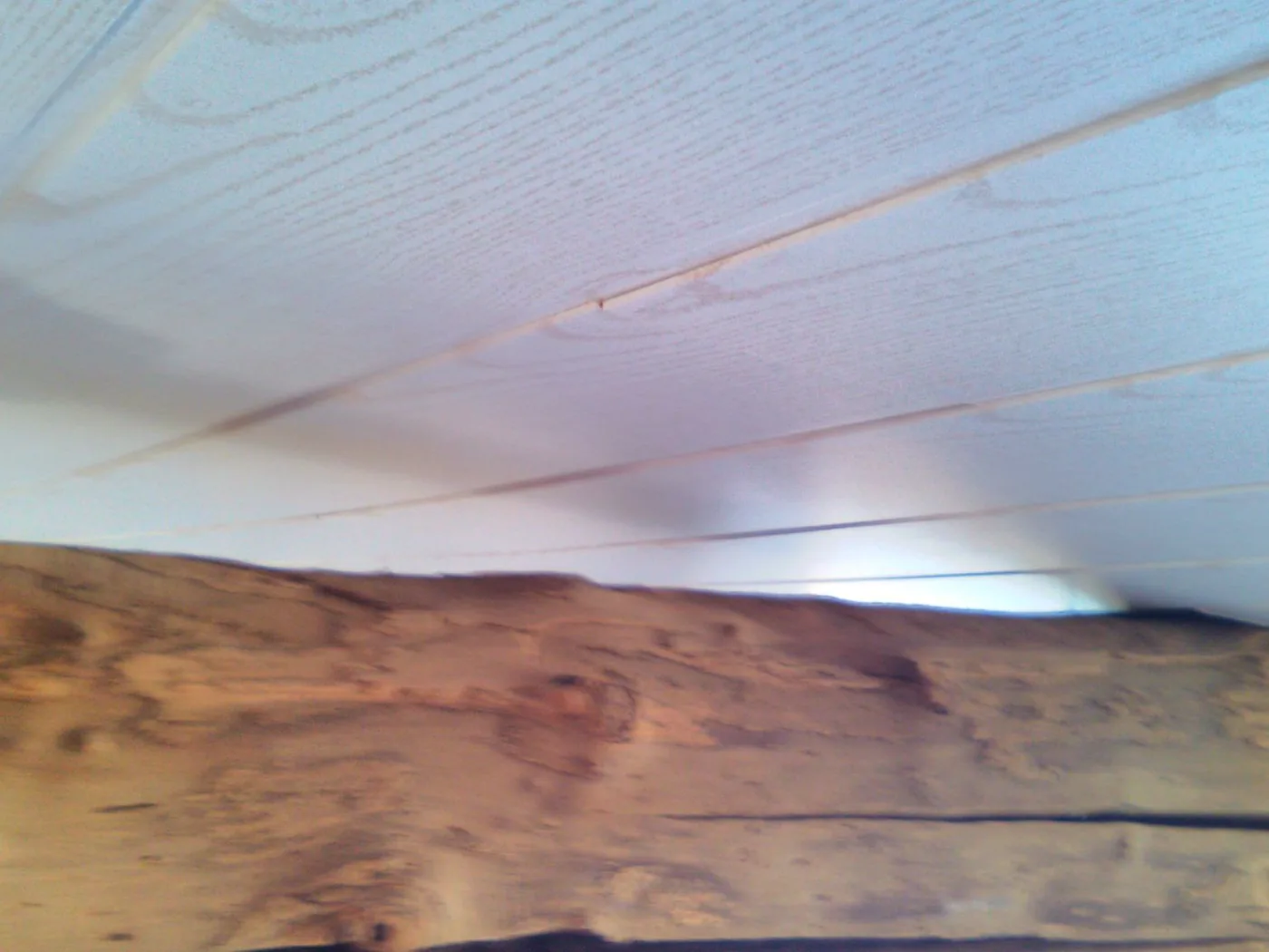 Plafond en lambris posé sous une poutre apparente